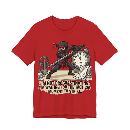 Red Bella+Canvas 3001 unisex tee with I'm Not Procrastinating ninja and clock graphic, on hanger